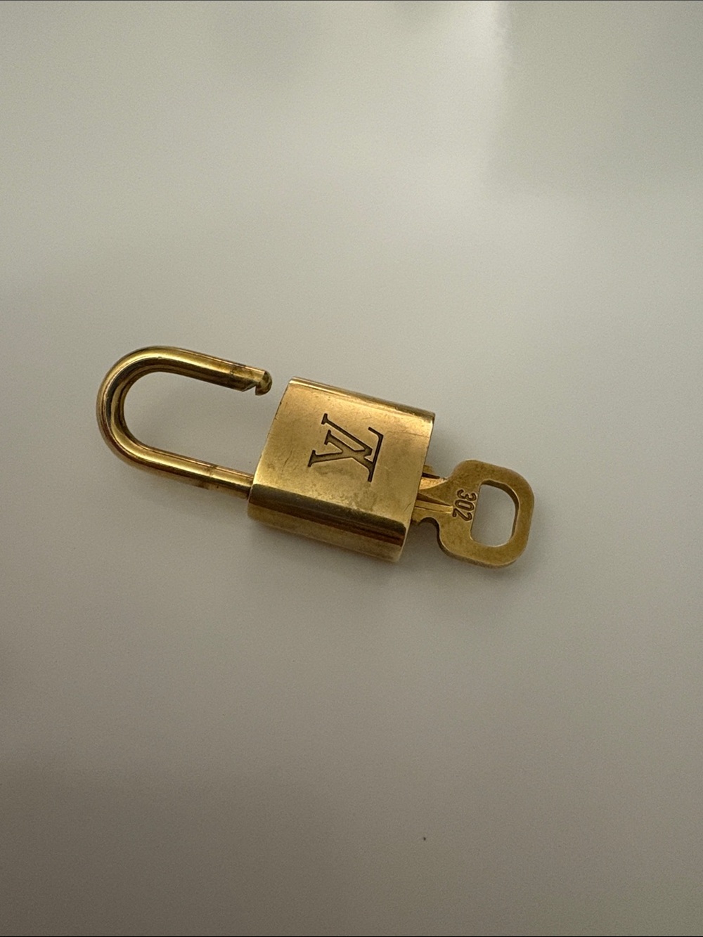 #302  Louis Vuitton Gold Padlock and Key Accessory